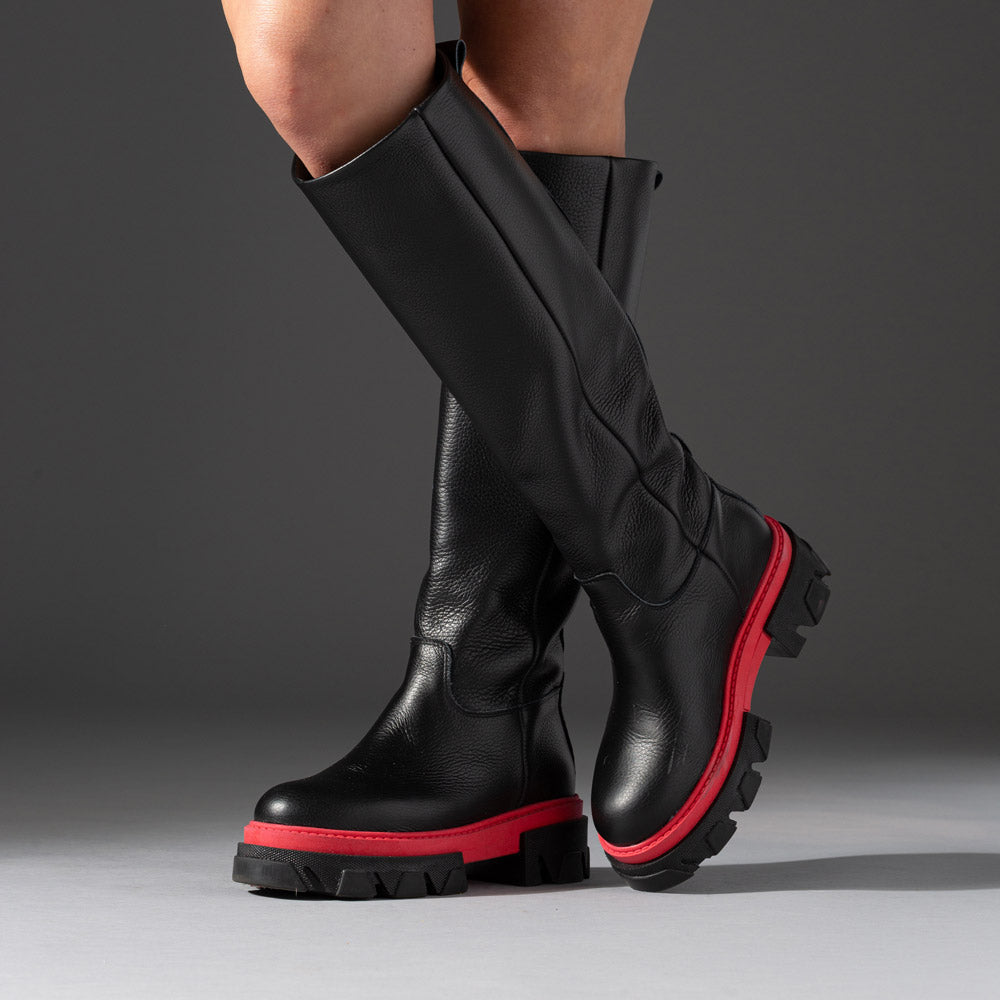 knee-high black leather boot with black and red lugged sole boot